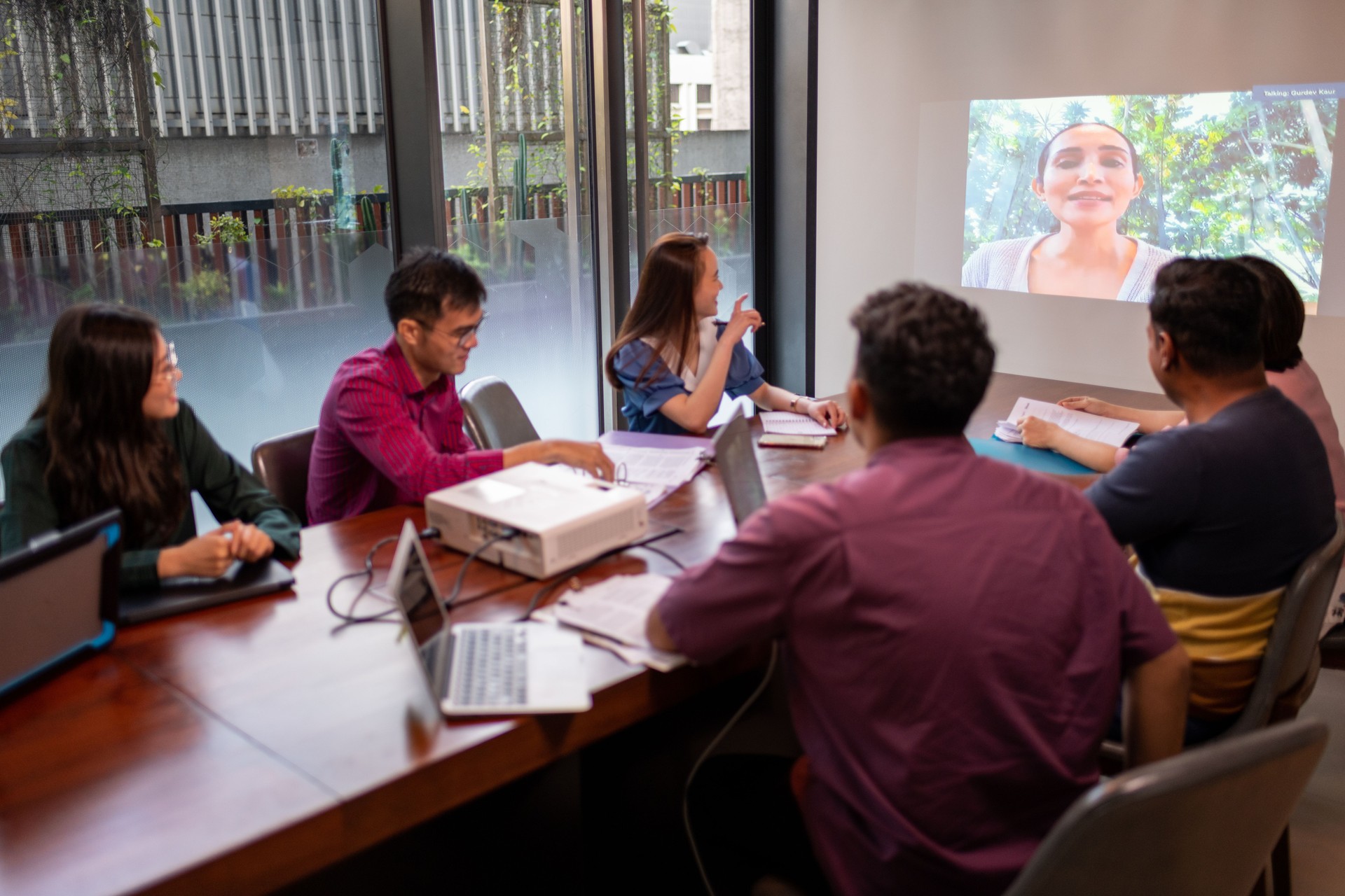 Des collègues asiatiques assistent à une réunion zoom avec une photo du patron